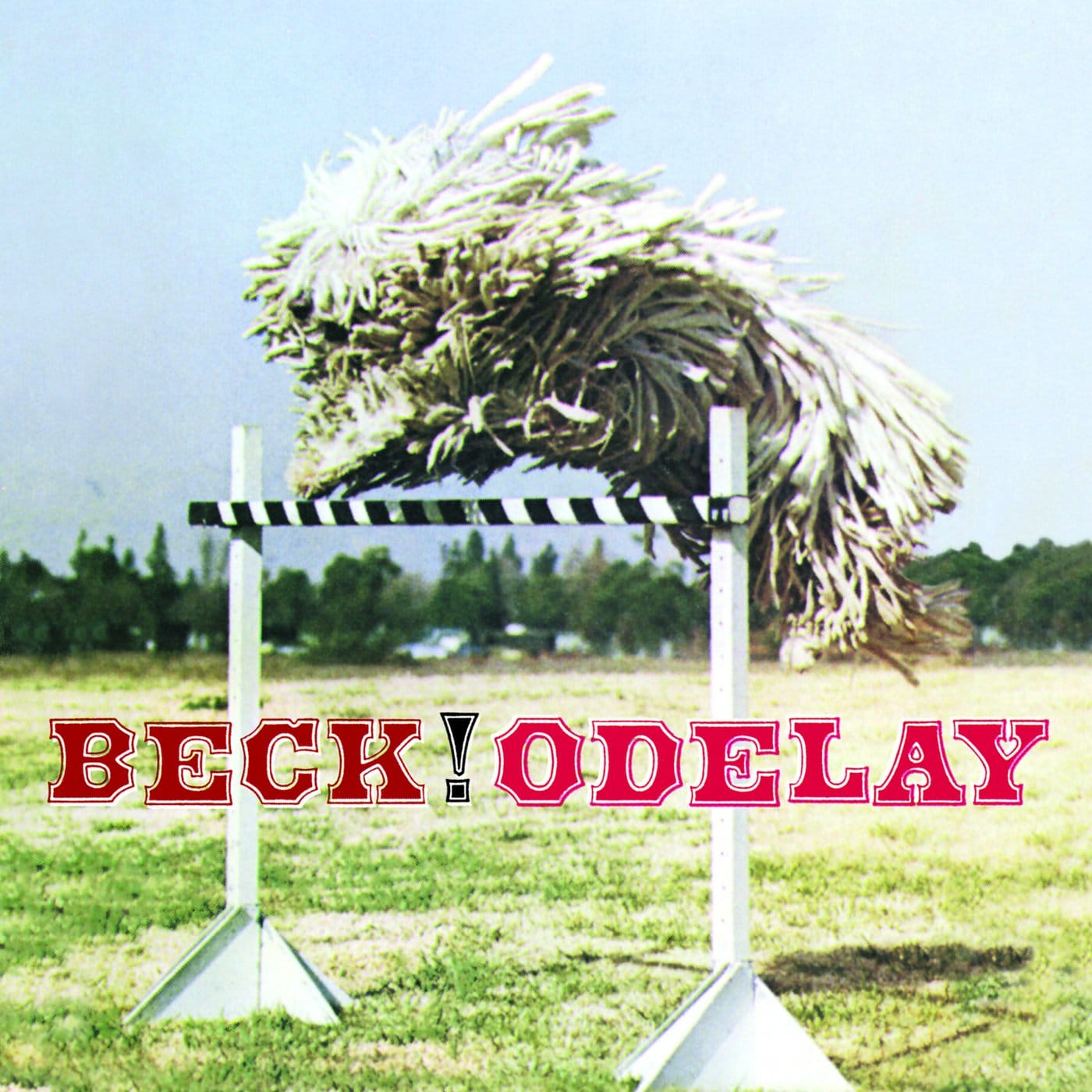 Grainy, sepia-toned photo of a Komondor sheepdog mid-leap over a hurdle, with "Beck" and "Odelay" set in bold, distressed wood-type lettering above it.