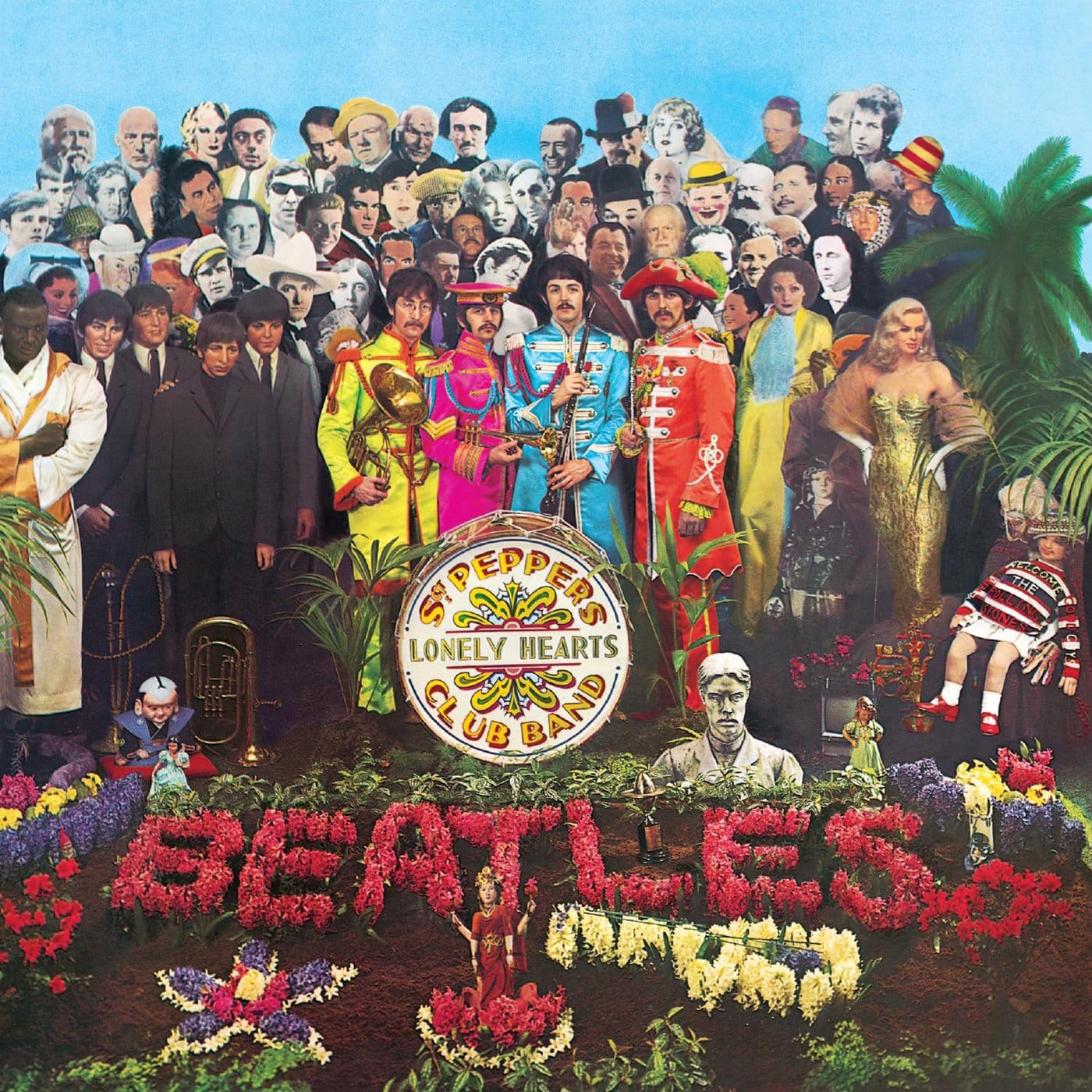 Front cover of The Beatles’ 1967 album Sgt. Pepper’s Lonely Hearts Club Band, showing the four members in colourful satin military uniforms standing behind a bass drum, surrounded by a crowded tableau of 88 life‑size cut‑outs and wax figures of celebrities, historical icons and cultural figures, designed by pop artists Peter Blake and Jann Haworth and photographed by Michael Cooper.