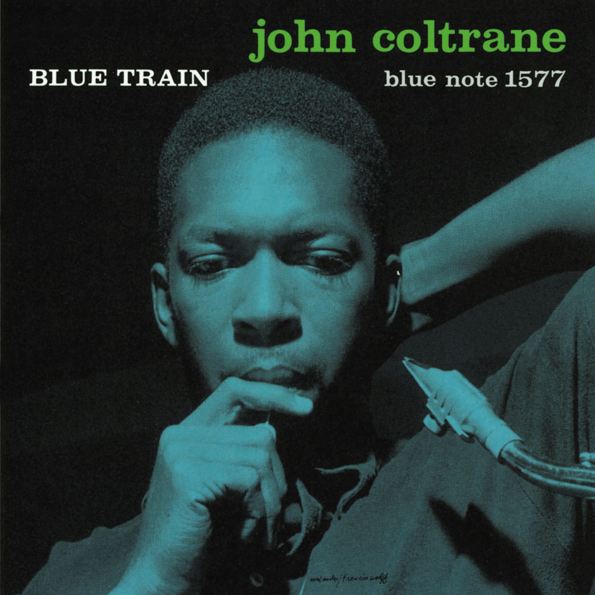 Front cover of John Coltrane’s 1957 Blue Note album Blue Train, featuring Francis Wolff’s portrait of Coltrane in a pensive pose, his face and saxophone mouthpiece bathed in a moody blue wash, with Reid Miles’ bold “Blue Train” typography.