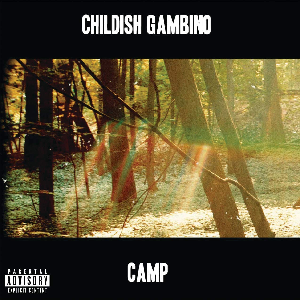 Album cover for Childish Gambino's Camp, showing a sunlit forest of bare tree trunks with a diagonal rainbow-coloured light streak crossing the frame, letterboxed in black with the artist name and album title in stencil-style lettering.