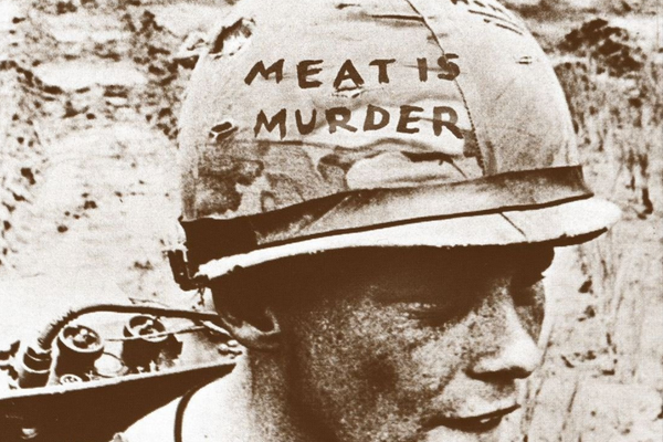 Meat Is Murder album cover by The Smiths, featuring a black-and-white photograph of a young man eating meat, with the album title and band name printed in white text